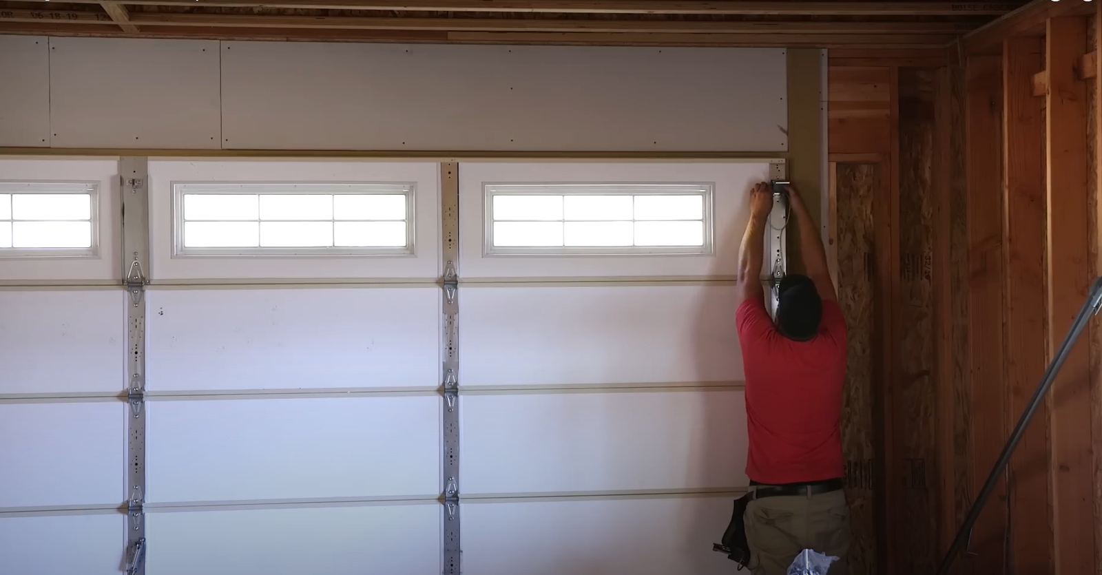 Technician performing a garage door replacement on a residential home in Upper Arlington, showcasing new modern garage doors and professional installation.