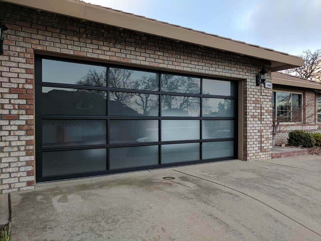 A professional technician from a local garage door repair company in Upper Arlington fixing a residential garage door with specialized tools.