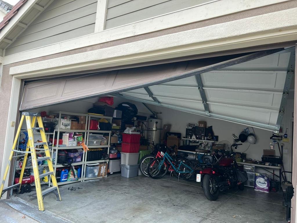 A technician performing same-day garage door repair in Upper Arlington, adjusting garage door springs and inspecting garage door tracks for proper function.