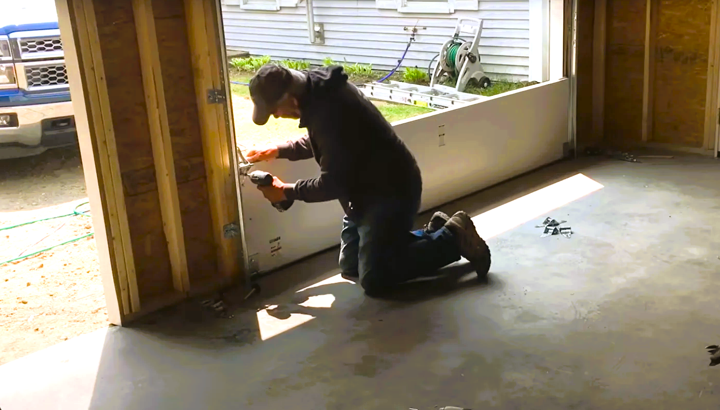 Professional technician completing a garage door installation at a residential home in Upper Arlington, showcasing new garage door panels and modern hardware.